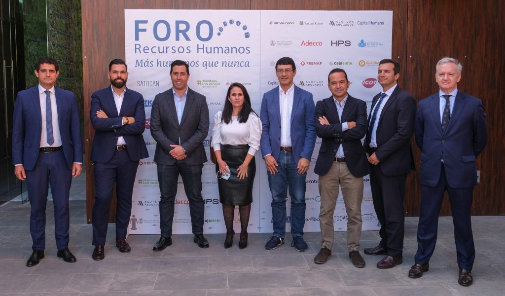 Ocho profesionales del sector de RRHH vestidos de business delante de un cartel del "Foro Recursos Humanos Canarias".