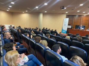 El público escucha atentamente a un orador en una sala de conferencias.