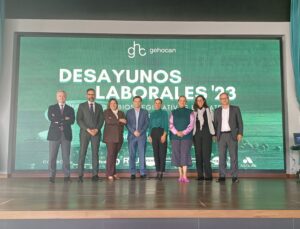 Un grupo de ocho personas se encuentra en el escenario frente a una pantalla grande que muestra "Desayunos Laborales '23" en un evento de Gehocan.
