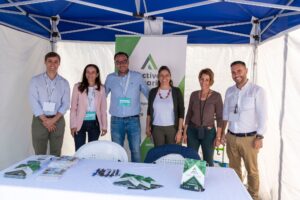 Un grupo de siete personas se encuentran bajo una carpa en un stand de eventos con folletos y bolígrafos sobre la mesa. Un cartel detrás de ellos dice "Activa Canarias".