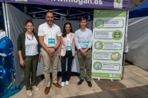 Cuatro personas posan frente a un stand con información sobre oportunidades de empleo.