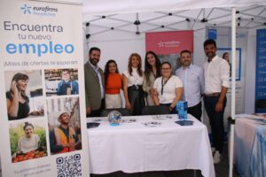 Grupo de personas detrás de una mesa con material informativo en un stand de la feria de empleo Eurofirms.