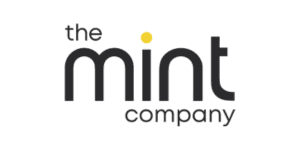 Logotipo de "the mint company" con "the" en letras minúsculas encima de "mint" en letra más grande y en negrita y "company" en letras minúsculas más pequeñas debajo de "mint". El punto sobre la "i" en "mint" es amarillo y refleja las nuevas conexiones en Job Dating 2023.